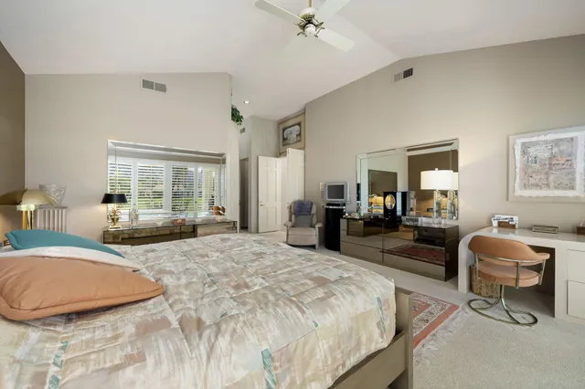 a bedroom with furniture and a large mirror