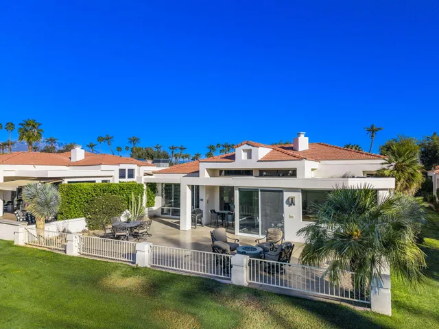 a view of house with swimming pool and outdoor seating