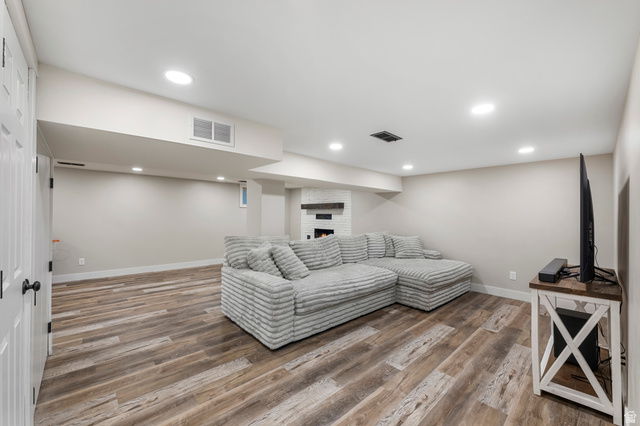 523 South Main Street Payson, UT 84651 - Photo 26 of 41 Spacious room featuring wood-finish flooring, recessed lighting, a fireplace with a stone surround, and an egress window