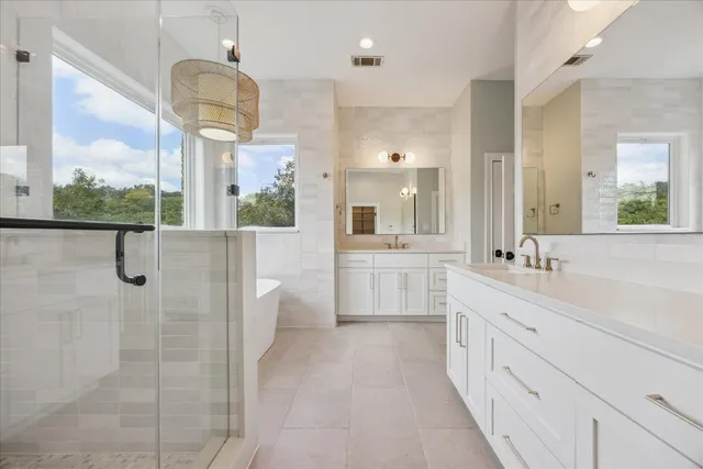 a large white bathroom with a double vanity sink a mirror and a shower