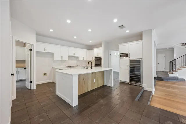 a large white kitchen with a refrigerator and a stove top oven