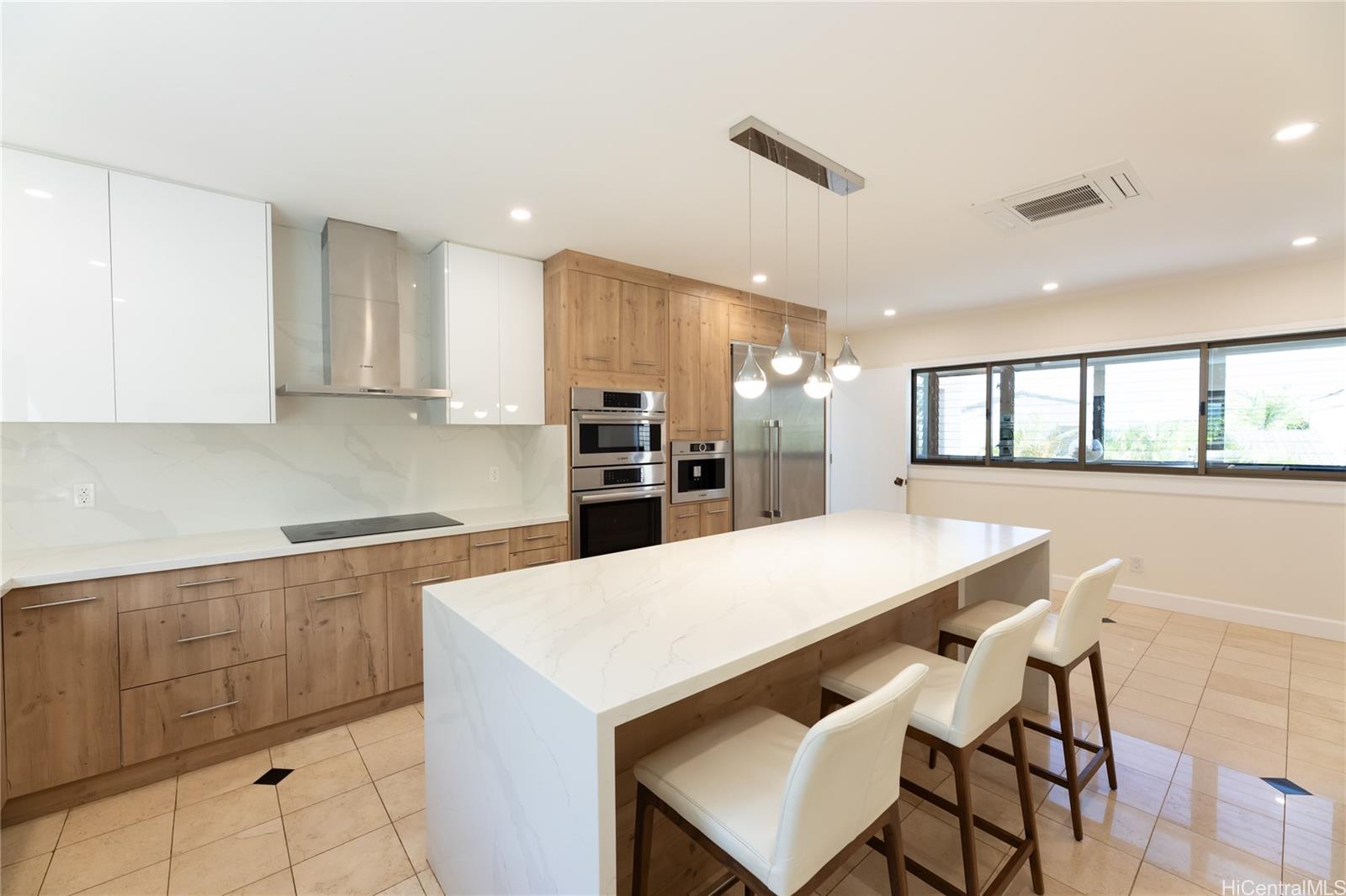 1632 Ihiloa Loop Honolulu, HI 96821 - Photo 11 of 24 a kitchen with a dining table chairs and refrigerator