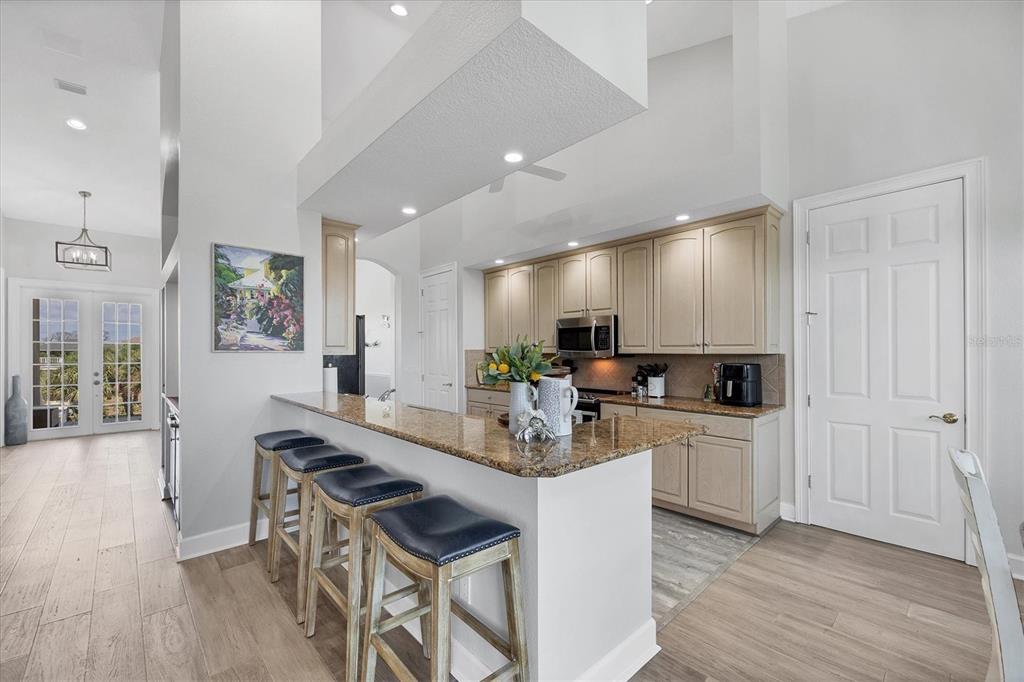 71 North Gulf Boulevard Placida, FL 33946 - Photo 21 of 52 a kitchen with stainless steel appliances kitchen island granite countertop a stove a sink a refrigerator and white cabinets with wooden floor