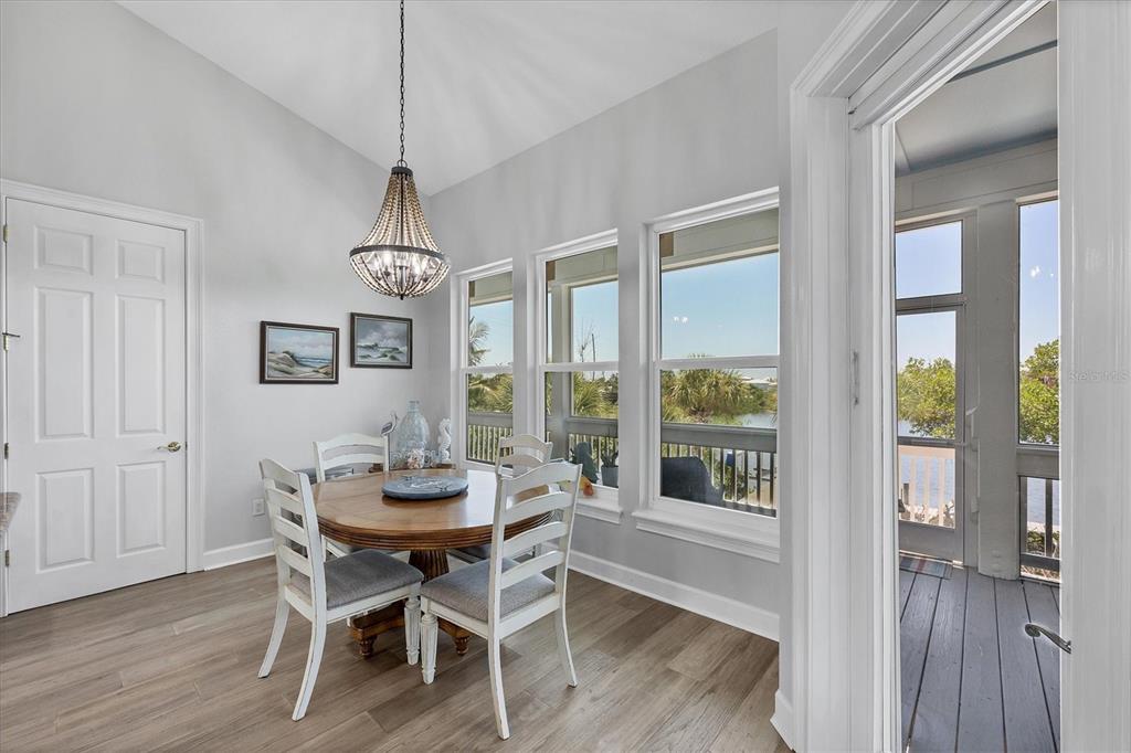 71 North Gulf Boulevard Placida, FL 33946 - Photo 23 of 52 a dining room with wooden floor a chandelier a glass table and chairs