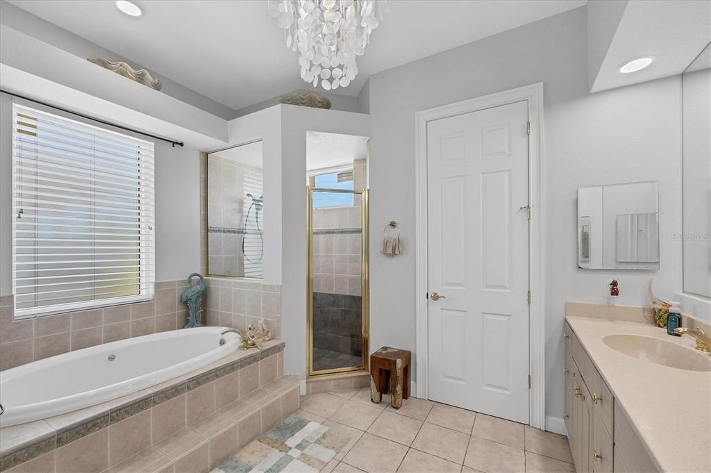 71 North Gulf Boulevard Placida, FL 33946 - Photo 27 of 52 a bathroom with a tub a sink and a large mirror