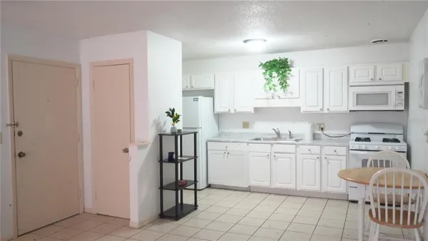 a kitchen with white cabinets and appliances