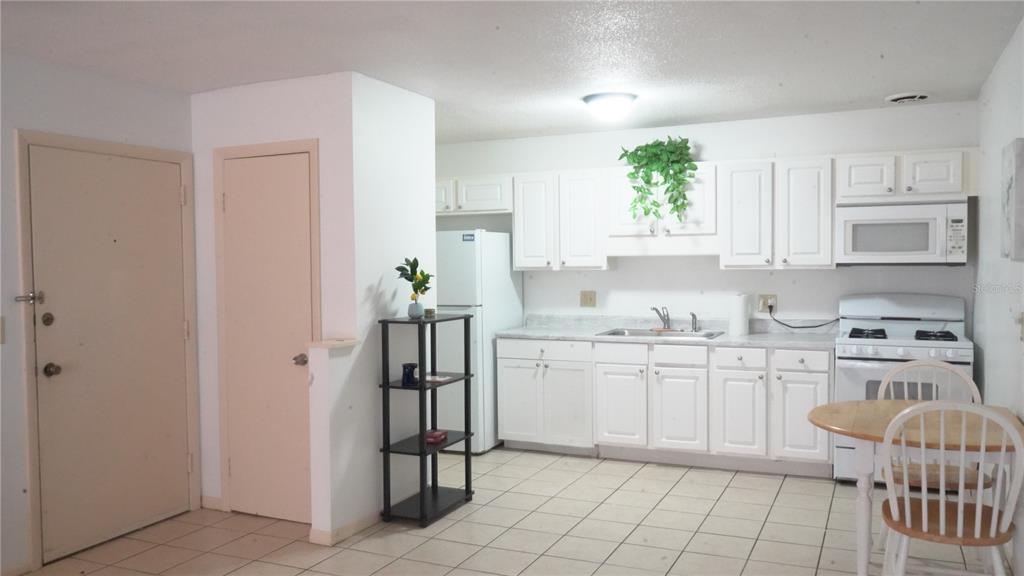 1700 Southwest 16th Court, Unit J4 Gainesville, FL 32608 - Photo 3 of 21 a kitchen with white cabinets and appliances