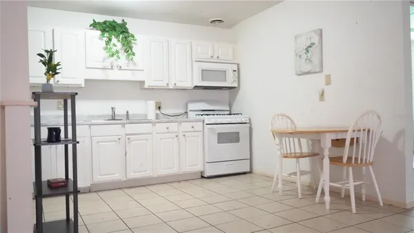 a kitchen with cabinets and chairs