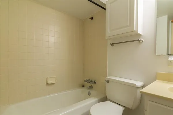 a white toilet sitting next to a bath tub