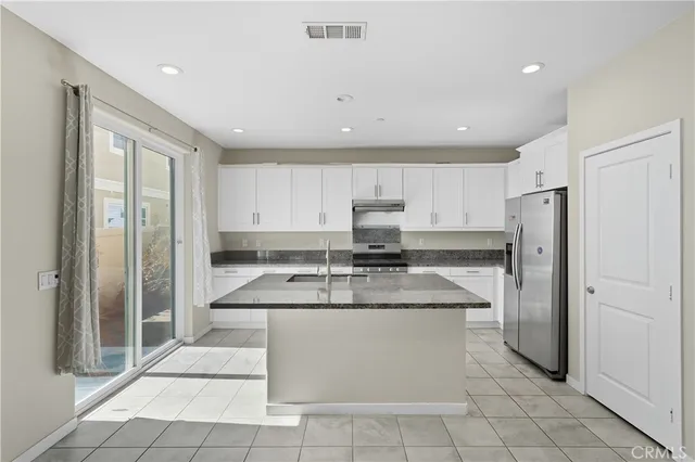 a kitchen with stainless steel appliances granite countertop a refrigerator sink and cabinets