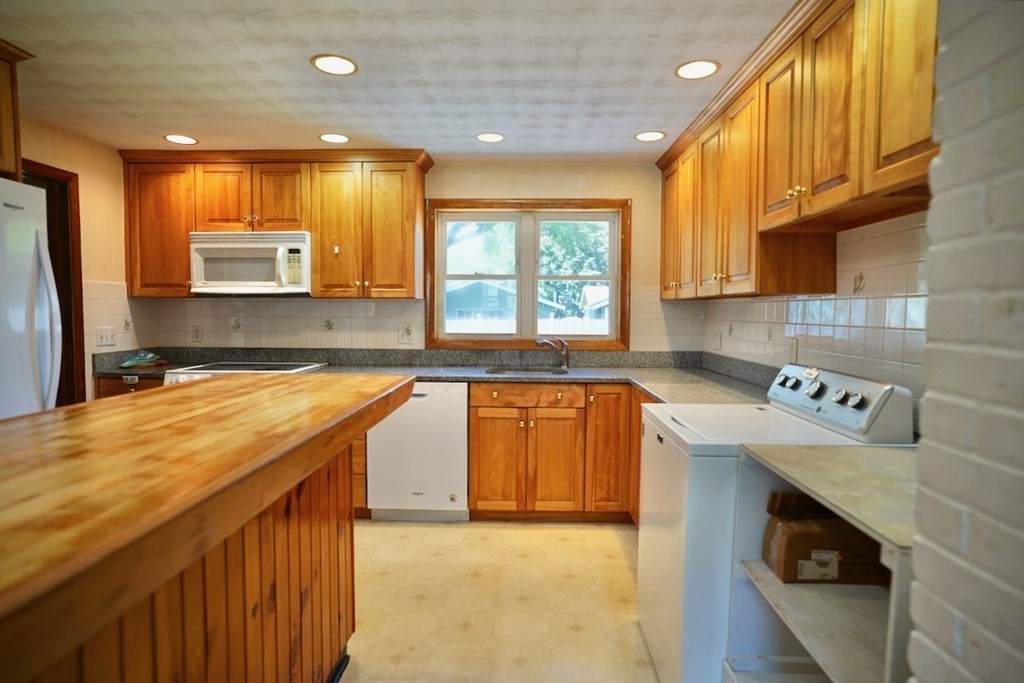 8 Dondi Road Beverly, MA 01915 - Photo 11 of 29 a kitchen with stainless steel appliances granite countertop a sink a stove and a wooden cabinets