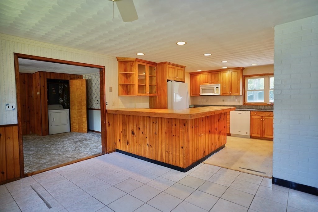 8 Dondi Road Beverly, MA 01915 - Photo 9 of 29 a view of a kitchen with kitchen island granite countertop a refrigerator and a sink