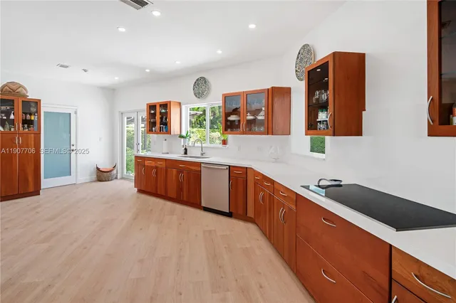 a large kitchen with stainless steel appliances granite countertop a sink and a refrigerator