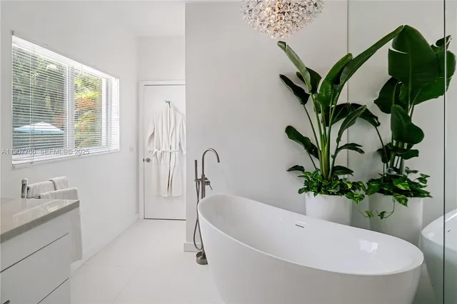 a white bath tub sitting in a bathroom next to a window