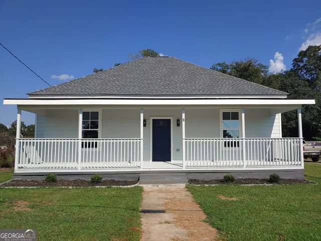 a front view of a house with a garden