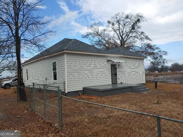 a view of a house with backyard and trees