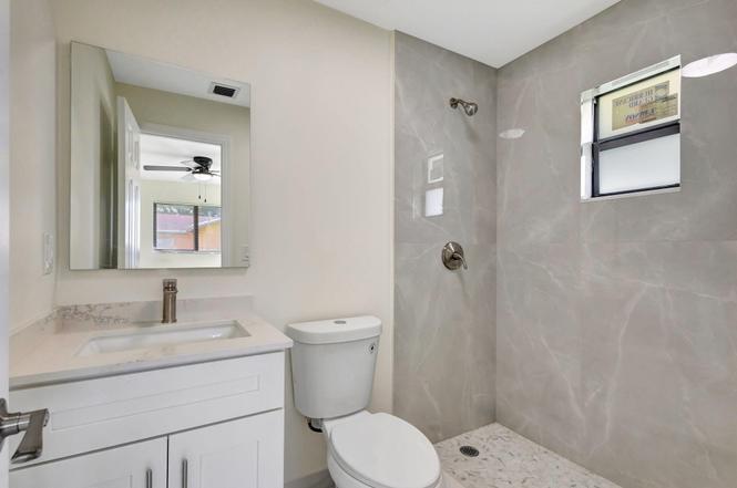 2016 Avenue South Riviera Beach, FL 33404 - Photo 10 of 17 a bathroom with a granite countertop toilet sink and mirror