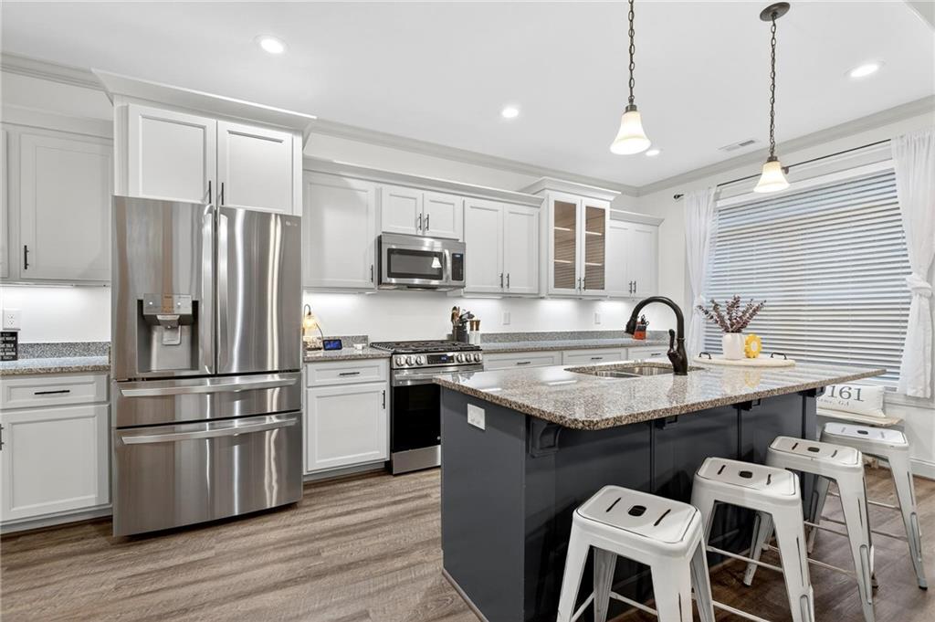 4 Tahlequah Street Northeast Rome, GA 30161 - Photo 26 of 52 a kitchen with stainless steel appliances granite countertop a sink a stove a refrigerator and island with wooden floor