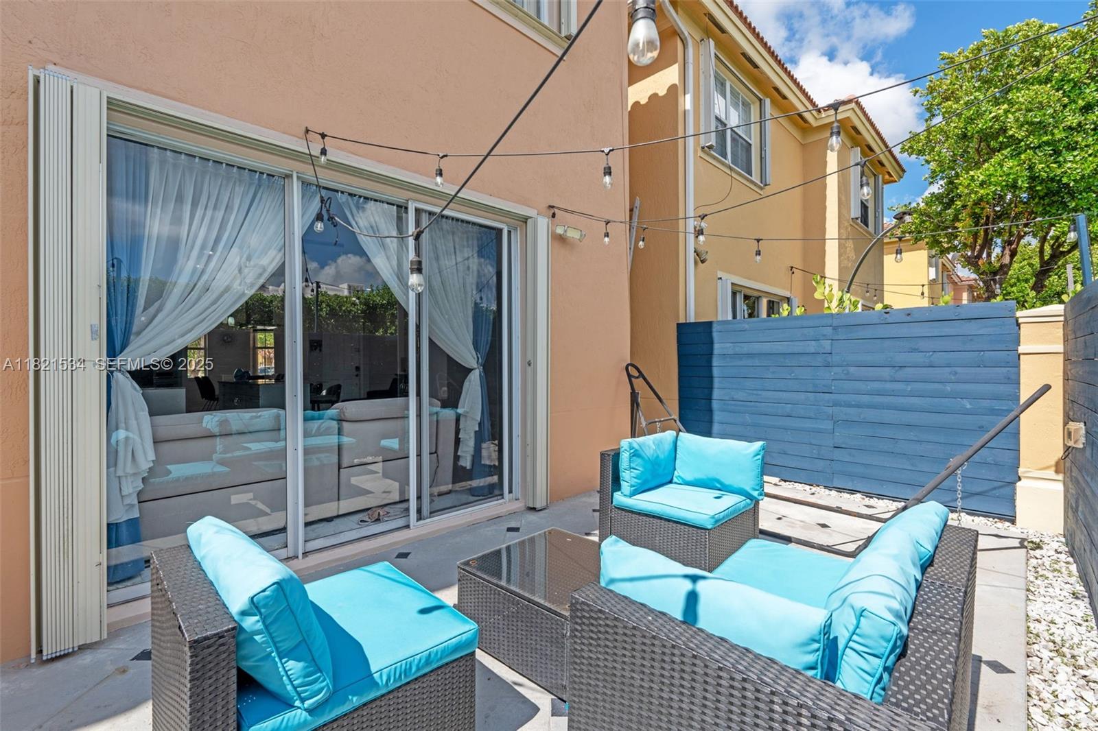 13745 Southwest 113th Lane Miami, FL 33186 - Photo 8 of 53 a view of a patio with a table and chairs and floor to ceiling window and wooden fence