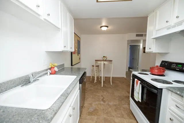 a kitchen with a sink stove and white cabinets