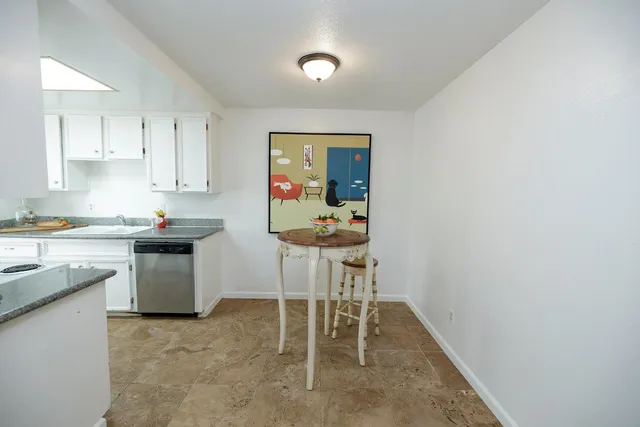 a kitchen with stainless steel appliances granite countertop a sink and a refrigerator