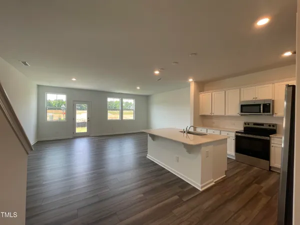 a kitchen with stainless steel appliances granite countertop a stove and a wooden floors