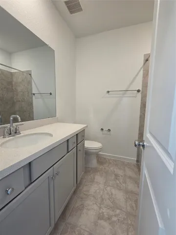 a bathroom with a granite countertop sink a toilet and a mirror