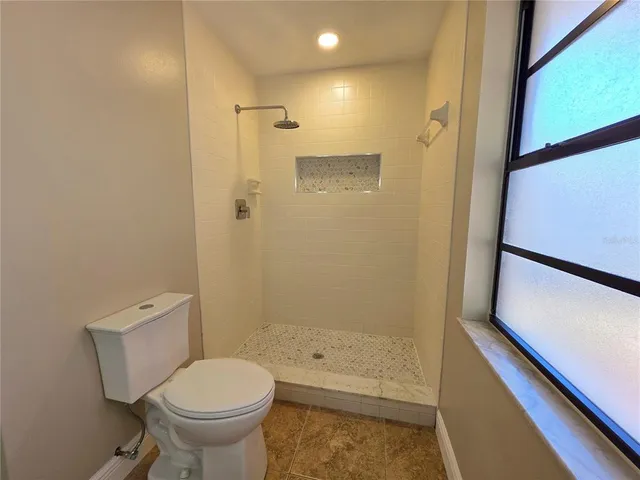 a large kitchen with kitchen island a sink stainless steel appliances and white cabinets