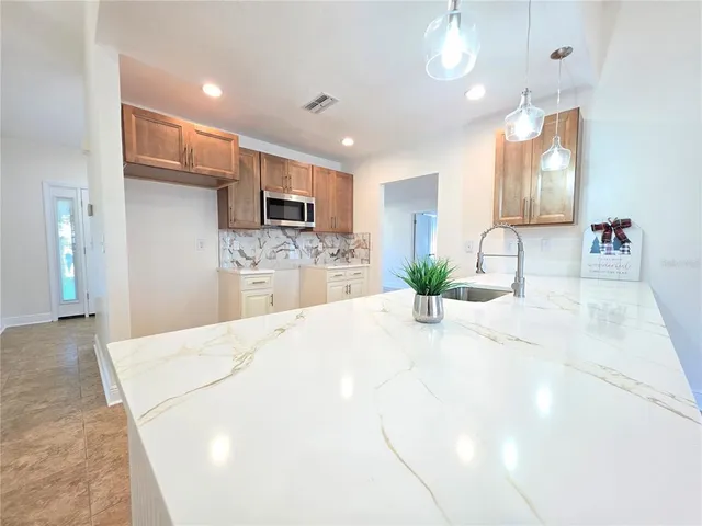 a large kitchen with a large counter top kitchen appliances and living room
