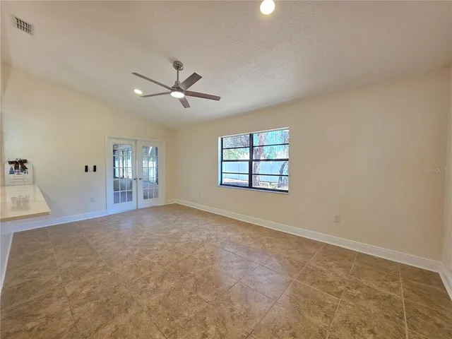 an empty room with windows and fan