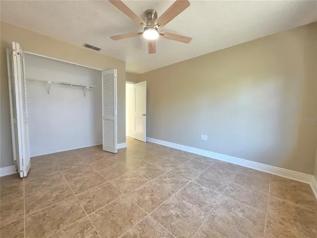 en empty room with windows and ceiling fan