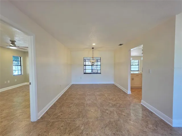 an empty room with windows and chandelier