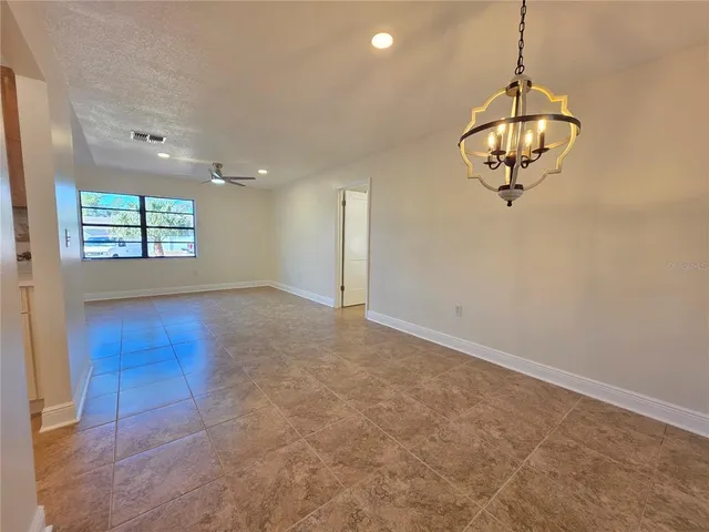an empty room with windows and fireplace
