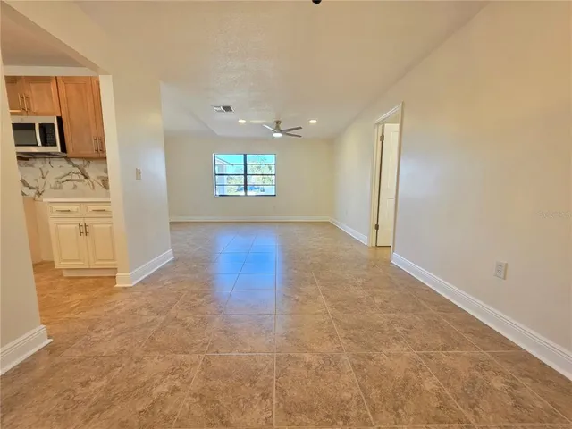 an empty room with windows and ceiling fan