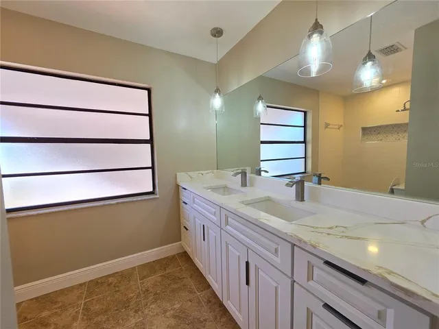 a large white kitchen with a sink a stove and a microwave