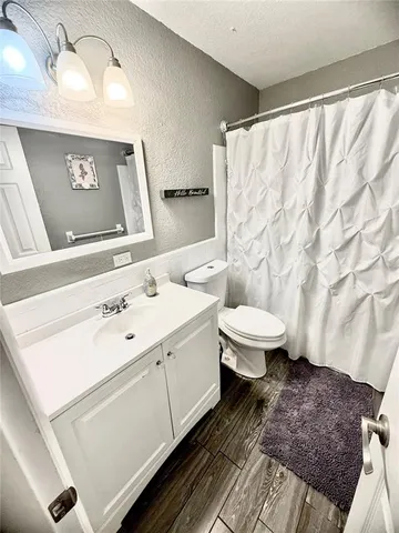 a bathroom with a sink a toilet and shower