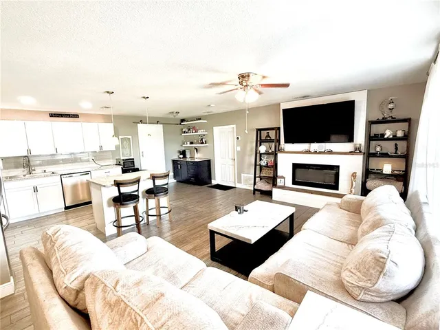 a living room with furniture a fireplace and a flat screen tv