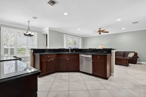 a kitchen with granite countertop a refrigerator oven a sink a dining table and chairs