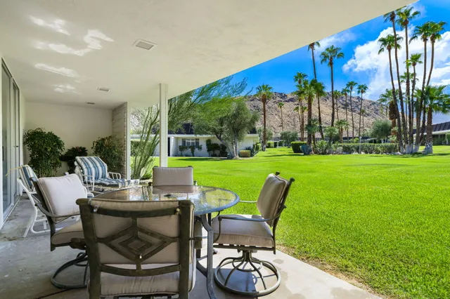 a view of a chairs and table in patio with a yard