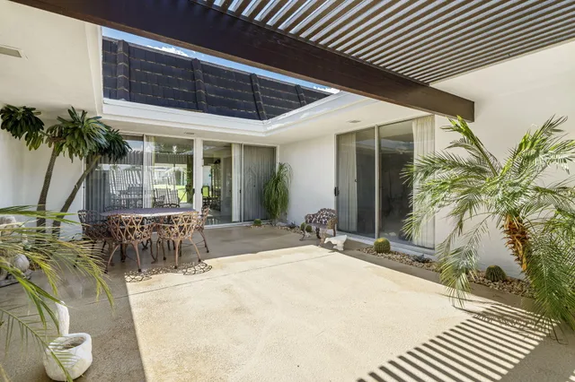 a swimming pool with outdoor seating and yard