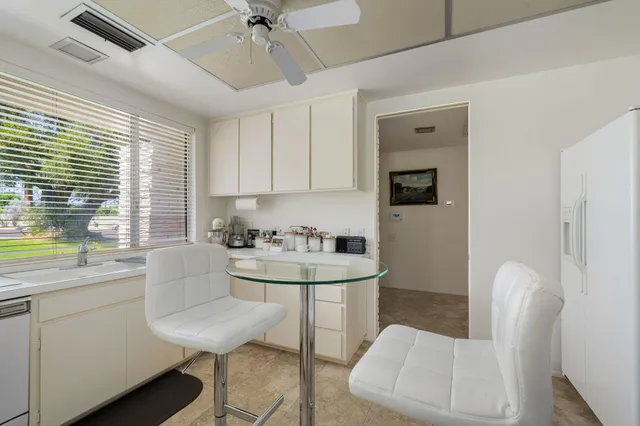 a kitchen with a white cabinets and chairs