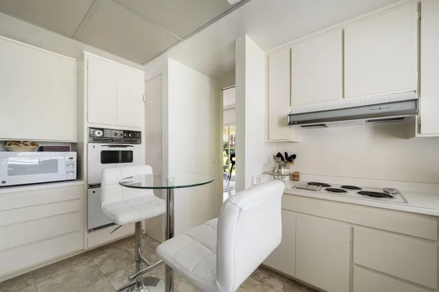 a kitchen with white cabinets and appliances