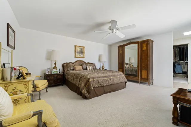 a spacious bedroom with a bed a couch and a dresser in it