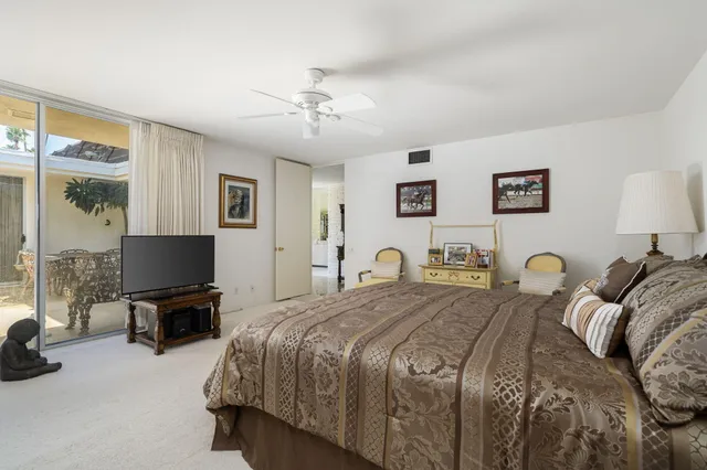 a bedroom with a bed a couch and large window