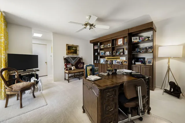 a work room with furniture a flat screen tv and a table