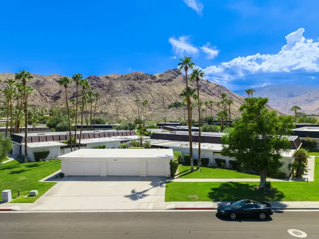 a front view of a house with a yard and trees