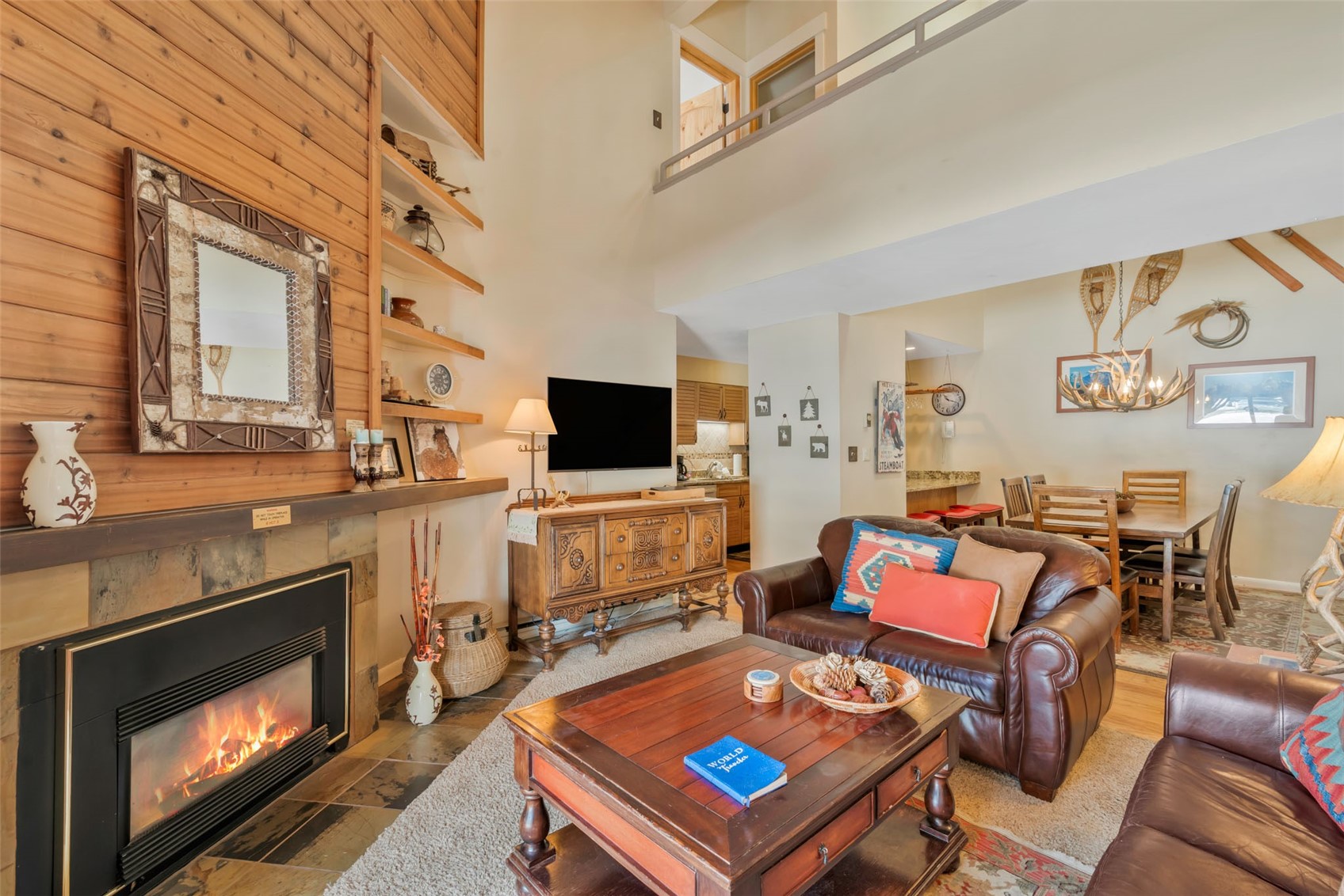 2025 Walton Creek Road, Unit 401 Steamboat Springs, CO 80487 - Photo 3 of 38 a living room with furniture a flat screen tv and kitchen view