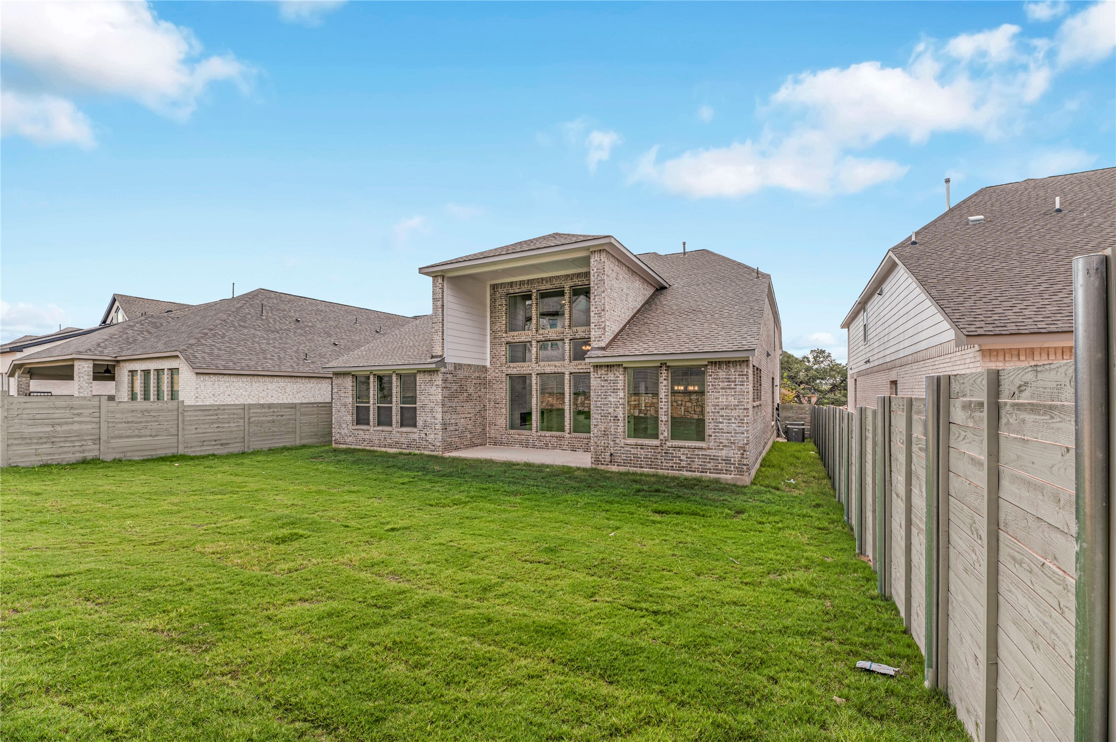1508 Rodeo Ridge Drive Georgetown, TX 78628 - Photo 29 of 37 Back of house featuring a fenced backyard, a patio area, brick siding, and roof with shingles