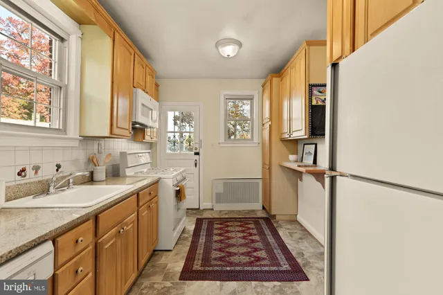 a view of a kitchen with a sink and dishwasher with wooden floor