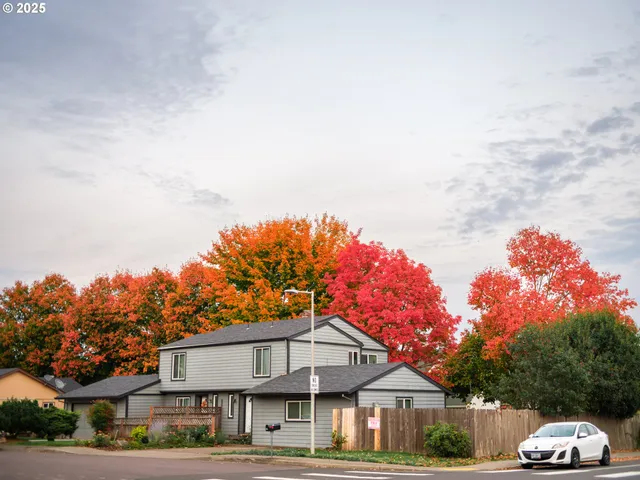 a front view of a house with a yard and trees